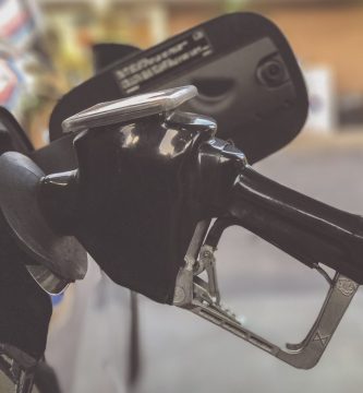 Persona abastece combustible en una estación de gasolina