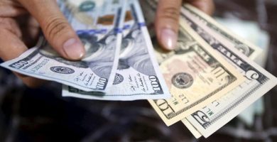 Persona contando billetes durante una operación de remesas y cambio de moneda